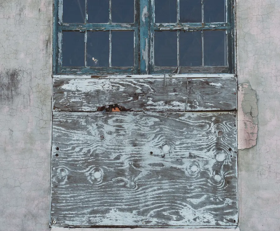 Window opening boarded up with timber